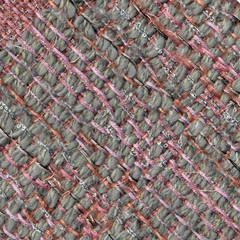 Close-up detail of handwoven woolen patterned fabric in pink and gray