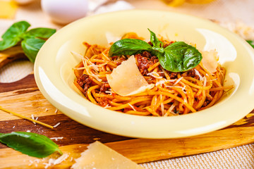 Spaghetti bolognese with minced meat and parmesan cheese in beige plate