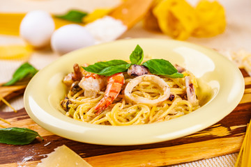 Spaghetti with seafood and parmesan cheese in beige plate