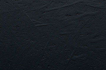 An uneven black painted granulated cork construction material surface