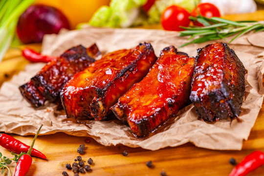 Grilled barbecue pork ribs with spices and herbs on wooden board