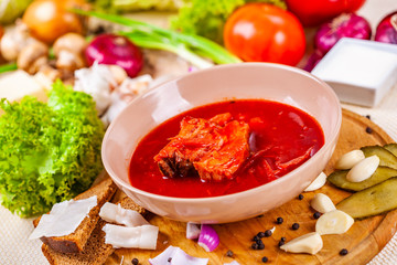 Borscht with vegetables and meat in pink plate. Ukrainian cuisine