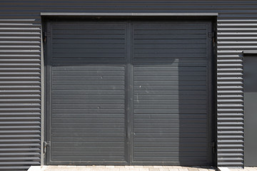 Double dark grey door in metal corrugated wall