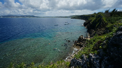 Boats with tourists came for snorkelling in Pacific Ocean, Okinawa Island, Japan. Panoramic view, landscape.