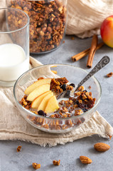 Healthy granola breakfast with apples and cinnamon on a gray table