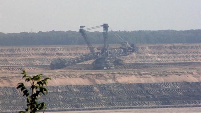 A huge strip mine used for mining lignite. Telephoto view of a bucket-wheel excavator used for excavating the top layers of a lignite strip mine.