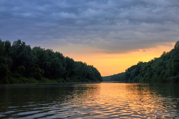 Beautiful bright dramatic sunset over Danube river with forest along riverside - obrazy, fototapety, plakaty