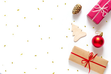 Christmas flat lay with gift boxes and Christmas decorations on a white background.