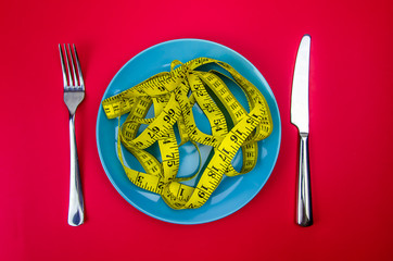 Top view. yellow measuring tape on the plate. Diet concept.
