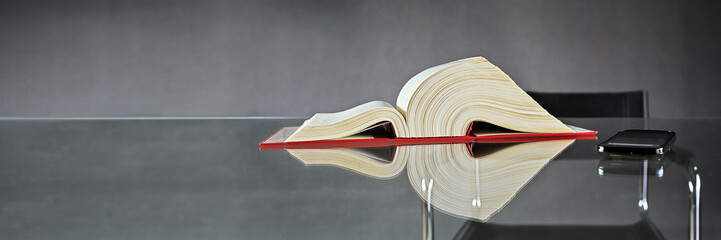 German Law, Book and Smartphone on Glass Table