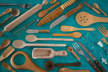 Many wooden spoons and rolling pin on the green background