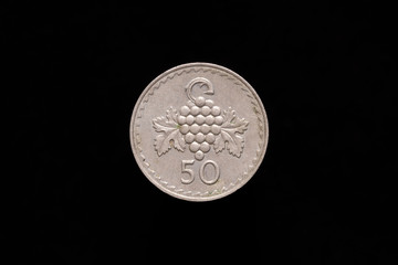 Republic of Cyprus old 50 Mils coin from 1981, reverse showing grape cluster. Isolated on black background