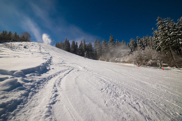 Snow blowers working at night on the slope