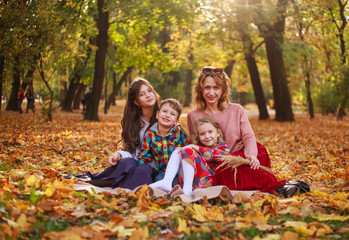 Fototapeta na wymiar Portrait of happy family in forest park in autumn colorful landscape, motherhood and carefree childhood in nature outdoors