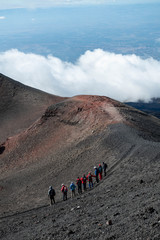 Landscape with Group of Hikers on Mount Etna with Black and Red Rocky Surface © Anna Hoychuk