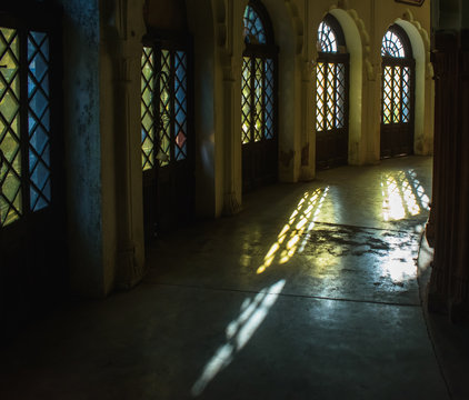 Bhopal, Madhya Pradesh, India - March 10 2019: The interiors of the Golghar museum in Bhopal, with long shadows of the stained glass windows falling on the surface of the circular corridors.