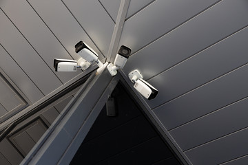 Bottom view of four white surveillance cameras
