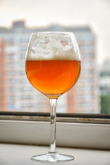 Glass with drink, glass with beer on the window