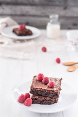 raspberry brownies served with fresh berries, white background, selective focus