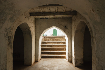 Murshidabad, West Bengal/India - January 15 2018: The elegant symmetry of the arches, stairs and architectural detail inside an old mosque in Murshidabad.