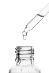 Cosmetic pipette with natural cosmetic oil on a white background with a glass bottle. Colorless bio...