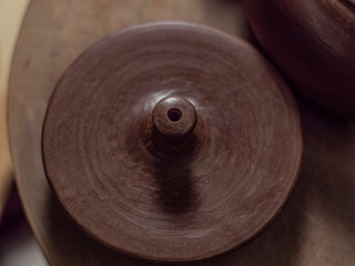 close-up handmade lid from Yixing clay for a Chinese tea ceremony on a wooden stand. Yixing clay teapot. brown ceramic teapot