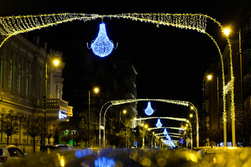 Illuminated christmas street with bokeh. New Year in Batumi, Georgia. City with New Years decorations. Neon lights and holiday city decorated with glowing Christmas lights