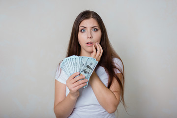 young, beautiful girl in a white T-shirt with money in hands