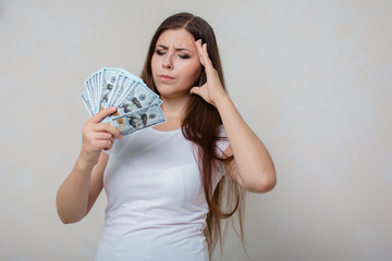 young, beautiful girl in a white T-shirt with money in hands