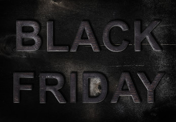 Charred inscription black Friday on a black wooden background