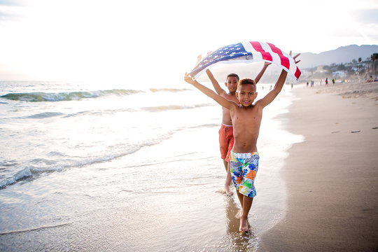 Patriotic fun at the beach brothers walking with the American flag