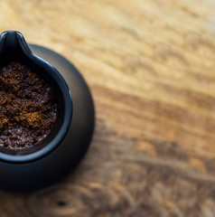 coffee with foam brewed in a ceramic Turk close-up on a wooden table, traditions and culture