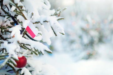 Christmas Poland. Xmas tree covered with snow, decorations and a flag of Poland. Snowy forest background in winter. Christmas greeting card.