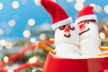 Red mug with hot chocolate and two snowmen in love made from marshmallows. Christmas and New Year composition.