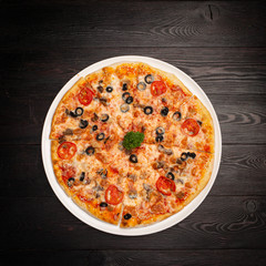 assorted pizza sliced into pieces with cheese, tomato and olives