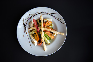 Dish in a white plate on a black background