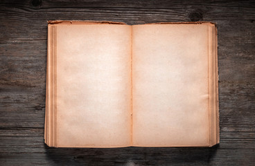 Vintage book, open, on old wooden table, with clipping path. Open Book blank on old wooden...