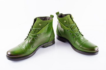 Pair of male green leather boots on white background, isolated product, top view.