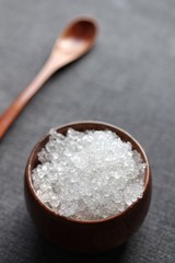 dead sea salt in bamboo bowl with spoon on dark background vertical closeup