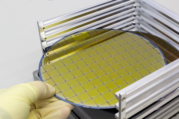 Silicon Wafers in steel holder box take out by hand in gloves A wafer is a thin slice of...