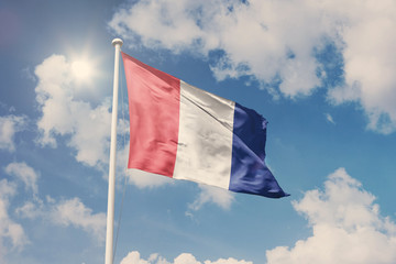 Flag of France, National symbol waving against cloudy, blue sky, sunny day