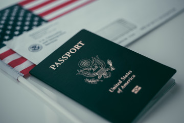 Passport of USA next to the Blurred Letter from USCIS and American flag.