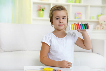   Little girl playing Plasticine at home         