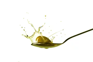 Fototapeten Tröpfchen, die aus einer Olive gewonnen werden, die auf einen Löffel voll Olivenöl fällt, isoliert auf Weiß © vetre