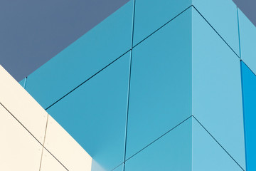 Geometric color elements of the building facade with planes, lines, corners with highlights and reflections for the abstract background and texture of blue, turquoise, white colors. Place for text