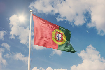 Flag of Portugal, National symbol waving against cloudy, blue sky, sunny day