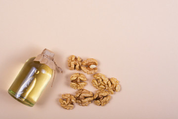 Bottle of peanut butter and walnut grains on a beige background close-up. Free space for an inscription.