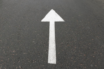 Road marking on asphalt with direction of movement