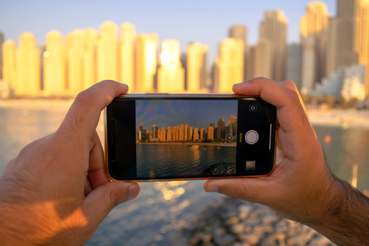 JBR. Panoramic view of Jumeirah Beach Residence skyscrapers through mobile camera. View from the screen and taking picture of Dubai. Man taking photo of beach.