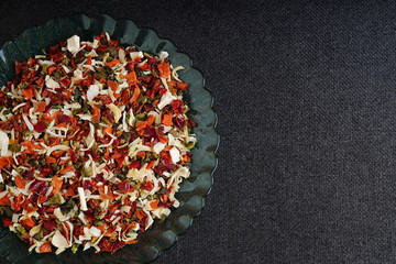 A big plate of vegetable condiment on a gray background.